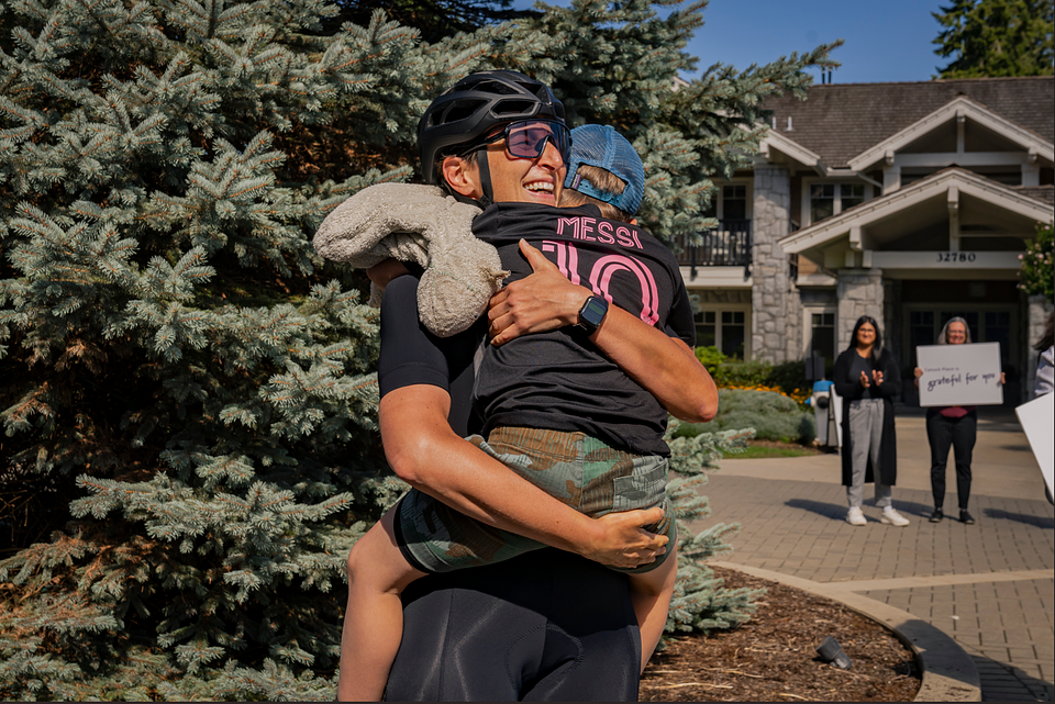 Mireille Larosa embracing her son, Theo as she arrives back at Canuck Place Abbotsford - Dave Lede House, crossing the finish line of Tour de Canuck Place.